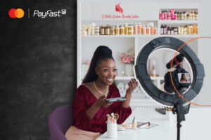 A lady doing a makeup tutorial with the PayFast and Mastercard logo in the background